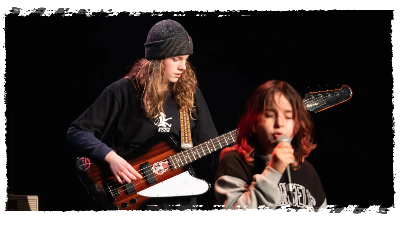 groupe-musique-ados-confiance Jeunes musiciens jouant en groupe avec guitare basse et chant, développant la confiance et l’esprit d’équipe.