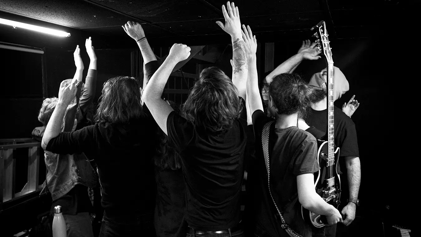 cohesion-equipe-team-building-musical-immersion-rock Team celebrating together with their hands raised after a rock music team-building workshop